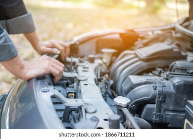 Close up hand man open car hood for repair as maintenance service. Man trying to repair a car engine, looking inside open bonnet - Shutterstock ID 1866711211