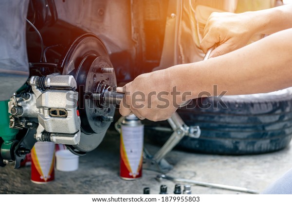 Close up hand a man repairing and Simple test\
bolt of car wheel after repair paint and  maintenance that can be\
made by yourself