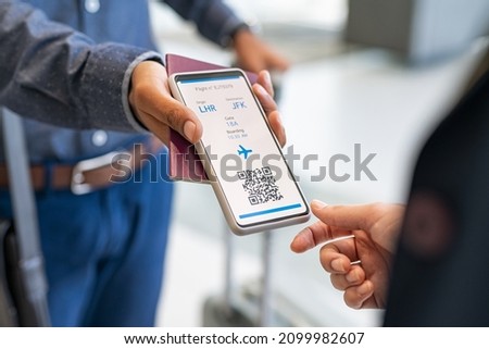 Close up hand of man showing electronic boarding pass to flight attendant on phone. Hostess checking electronic flight ticket at boarding gate. Check in counter and online air ticket at airport.