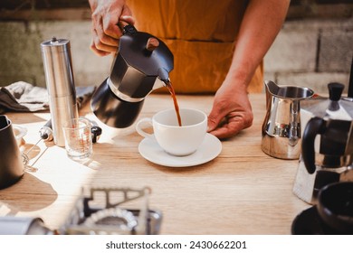 Close up hand Man using Italian classic Moka coffee pot pouring, coffee maker with equipment tool brewing table.
 - Powered by Shutterstock