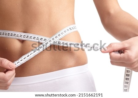 Close up of hand measuring her thin waist with a tape measure. Healthcare and woman diet lifestyle concept.