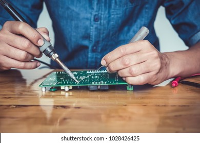 Close up of the hand men hold tool repairs electronics manufacturing Services, Manual Assembly Of Circuit Board Soldering. - Shutterstock ID 1028426425