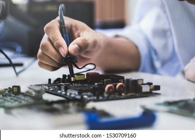 Close Up Of The Hand Men Hold Tool Repairs Electronics Manufacturing Services, Manual Assembly Of Circuit Board Soldering.

