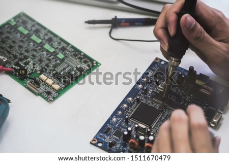 Close up of the hand men hold tool repairs electronics manufacturing Services, Manual Assembly Of Circuit Board Soldering.

