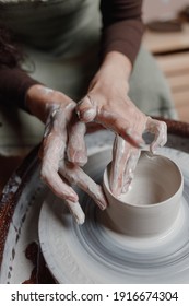 close up hand modeling pottery on a potter wheel in a cozy home workshop. Creating products from environmentally friendly clay with their own hands. Aesthetically beautiful female hands of the artist