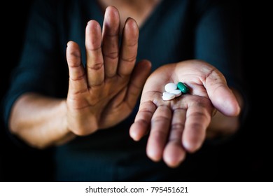 Close Up Hand Of Old Woman Holding A Pill On Black Background, Concept Illness And Healthcare