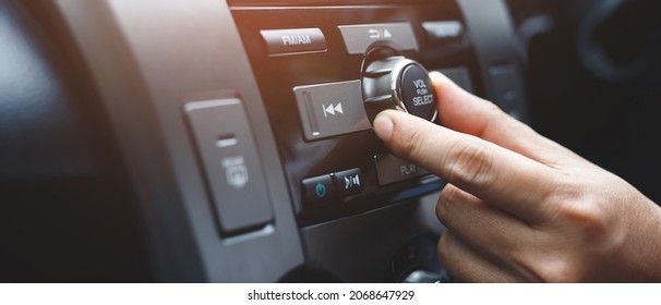close up hand open car radio listening. Car Driver changing turning button Radio Stations on His Vehicle Multimedia System. Modern touch screen Audio stereo System. transportation and vehicle concept - Shutterstock ID 2068647929