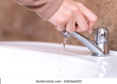 Close Up Hand Open Or Close Water Tap. Faucet And Saving Concept