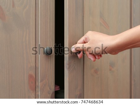 Close up hand open wooden cabinet.
