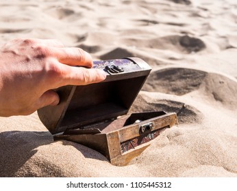 Close Up Hand Openning The Treasure Chest Buried In The Sand