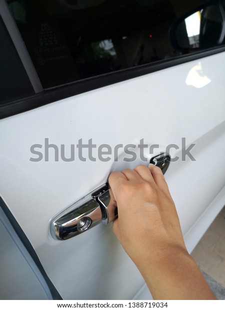 close up of a hand opens white car door, a man opens
car door