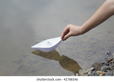 Close Up Of Hand And Paper Boat In River