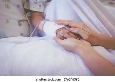 Close Up Hand Of Parent Holding Hand Of Child In Hospital, Saline Intravenous (IV) On Hand, Shallow Depth Of Field (DOF) Saline Intravenous (IV) In Focus. Vintage Picture Style.