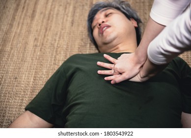 Close up hand of people  are doing first aid by Cardiopulmonary Resuscitation or CPR to elderly fat man with sudden cardiac arrest Because he has a heart problem, to health care concept. - Shutterstock ID 1803543922