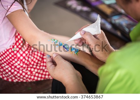 Close up hand of people making art paint on children arm