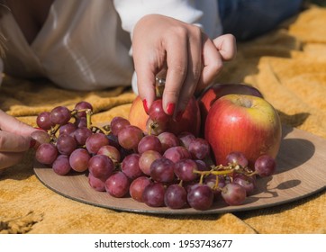 Close Up Of A Hand Picking Grapes From A Fruit Plate