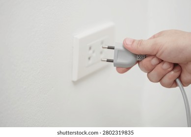 close up hand plugging adapter Electrical appliances with outlet socket plug  ,electric safety concept