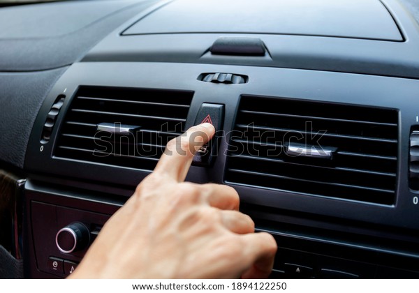 Close up hand press the emergency light in the car.\
Fingers press button for open the contract emergency light in car.\
Emergency button press for open emergency light warning sign symbol\
out side car