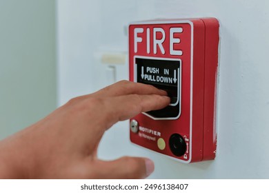 Close up of hand pressing fire alarm. - Powered by Shutterstock