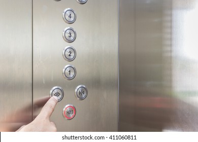 Close Up Hand Pressing Silver Elevator Button