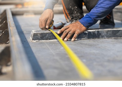 Close up hand professional engineer man using measure tape and working at precast concrete wall factory. Yellow tape measure construction tools. Heavy Industry Manufacturing Factory - Shutterstock ID 2334807815