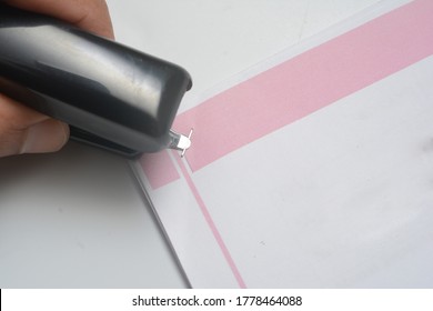 Close Up A Hand Is Pull Off Stapler On A Bunch Of Paper Using Back Of The Stapler