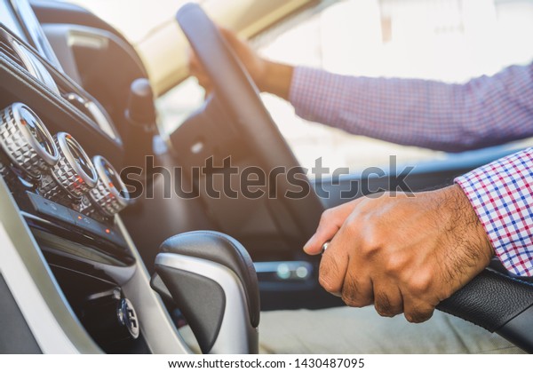 Close up hand push up car handbrake. Safety\
drive concept.