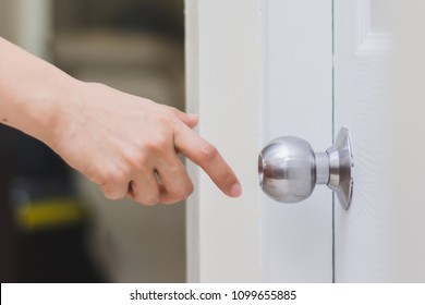 close up of woman’s hand reaching to door knob, opening the door - Powered by Shutterstock