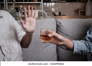 Close up hand rejecting glass of whiskey and alcohol, alcoholic concept.