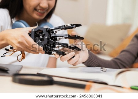 Close up hand robot model. human shake hand with robot. Girl students education study in classroom.