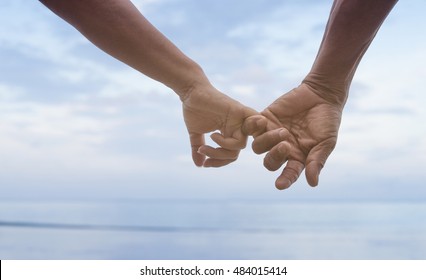 close up hand of senior couple hook each other's little finger together near seaside at the beach,filtered image,selective focus,love forever concept - Powered by Shutterstock