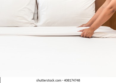 Close Up Hand Set Up White Bed Sheet In Hotel Room