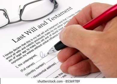 Close up of hand signing a Last Will and Testament document