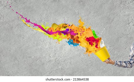 Close up of hand splashing colorful paint from bucket