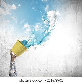Close up of hand splashing colorful paint from bucket