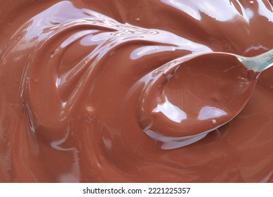 Close Up Of Hand Stirring Melted Chocolate With Spoon. Chocolate Surface, Melted Premium Chocolate Swirl. Top View.