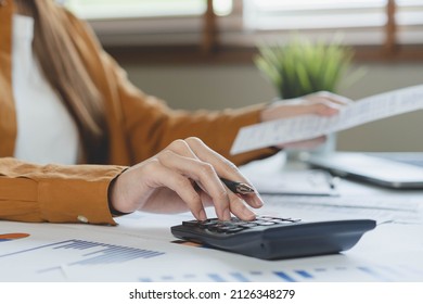 Close Up Hand Of Stress Asian Young Employee Business Woman Calculate Tax Income And Expenses, Bills, Credit Card For Payment Or Payday On Table At Home Office. Financial, Finance People Concept.