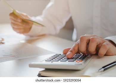 Close up hand of stress young asian businessman,male is pressing a calculator to calculate tax income and expenses, bills, credit card for payment or payday at home, office.Financial, finance concept. - Shutterstock ID 1923293054