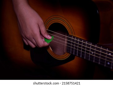Close up of a hand strumming or playing a guitar