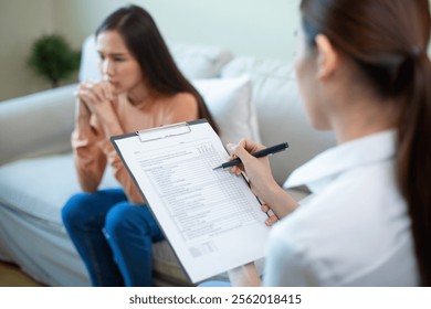 Close up hand taking notes on clipboard. Psychiatrist taking notes examining female patients therapy for mental symptoms and depression.