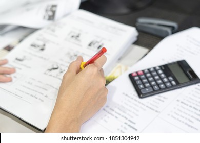 Close Up Hand Teacher Use A Red Pen Check Example Sheet And Examination  Equipment On The Wood Table And Use Desktop Computer Working In The Background