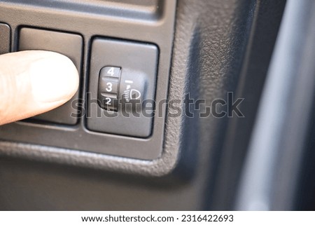 Close up hand. Technician checks car headlight switch for maintenance and adjusts car headlamp height