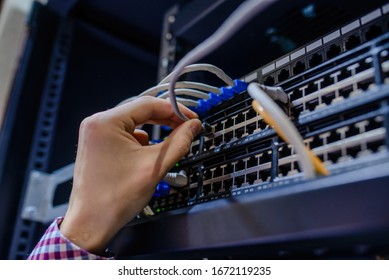 Close Up Hand Of A Technician/ It Engineer/ Connecting The Internet Network Cable In The Server Room Wireless System.