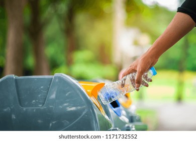 Close up hand throwing empty plastic bottle into the bin.