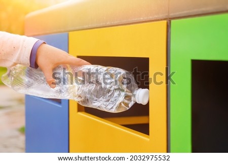 Close up hand throwing plastic bottle recycling container garbage sorting rubbish collection bin. Hand kid put bottle plastic trash can. Reduce waste recycle bins. Garbage recycling plastic trash bins