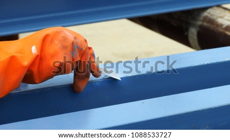 Close up hand with tool repair  a surface for painted structure, selective focus