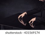 Close up of a hand touching smart table with copy space on black background