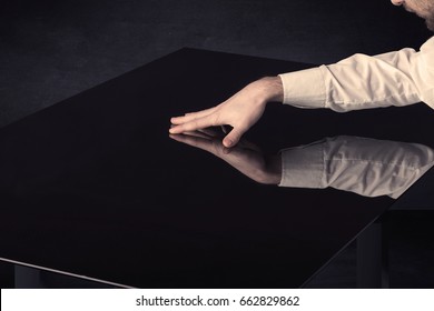 Close up of a hand touching smart table with copy space on black background
