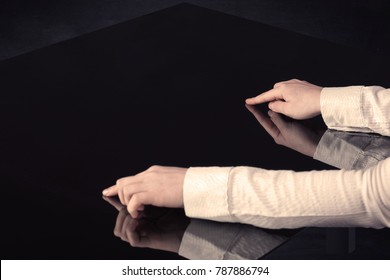 Close up of a hand touching smart table with copy space on black background