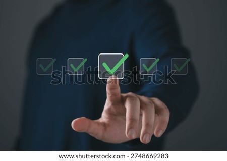 Close up of hand touching virtual checkbox with green check mark, symbolizing approval, quality control, task completion and online verification. Business checklist and digital confirmation concept.